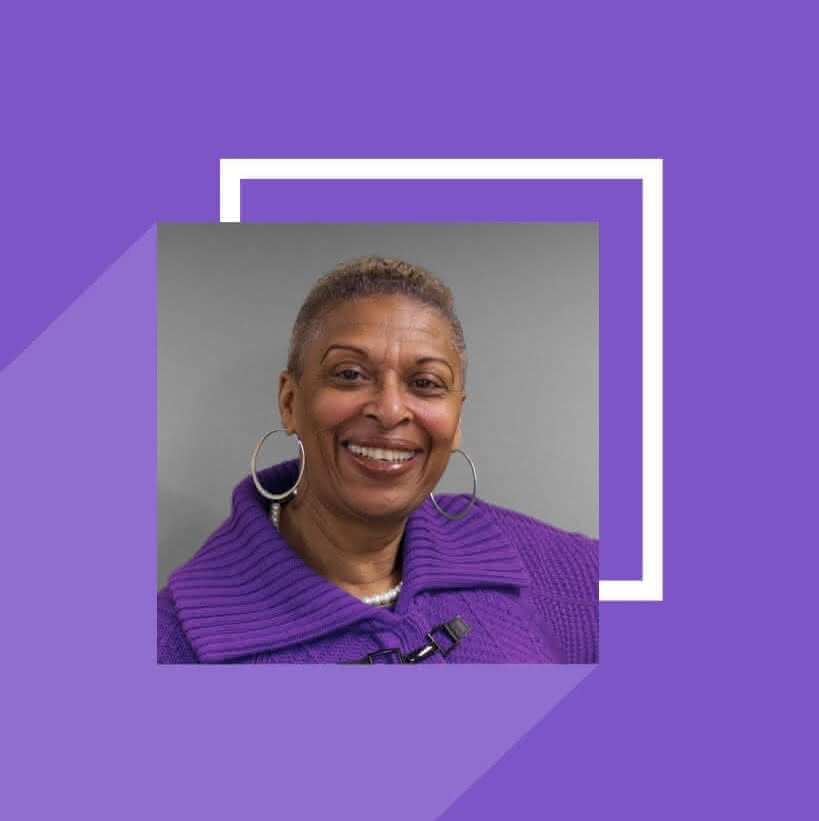 A portrait of Valerie Randleman in a purple sweater. The background is a matching shade of purple, and inludes abstract geometric shapes.